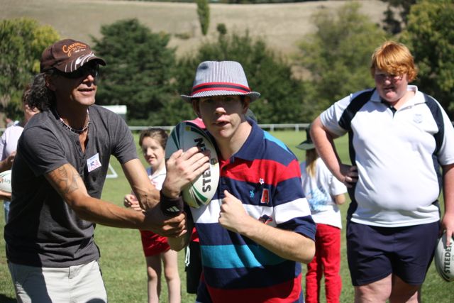 Support worker Allan Fogg encourages Steven Munnerley to take the shot, assisted by Yass High School student Luke Miller.
