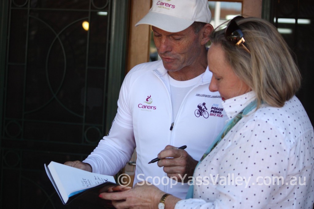 Pollie Pedal founder and former Prime Minister Tony Abbott signs a copy of his book for Yass Valley mayor Rowena Abbey. PHOTO: Katharyn Brine